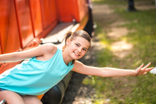 Young and happy woman pulling face out the train door looking for somebody at the railway station