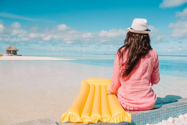 Young happy woman relaxing in a swimming pool