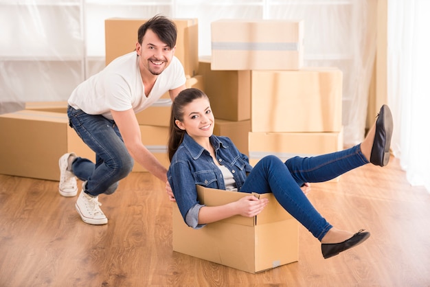 The young happy woman sitting in a cardboard box.