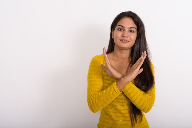 Young happy woman smiling while showing stop hand gesture with both arms