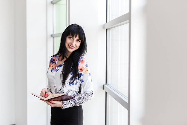 Young Happy woman standing near the window