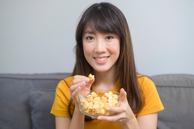 A young happy woman watching movie and relaxing at home