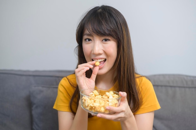 A young happy woman watching movie and relaxing at home