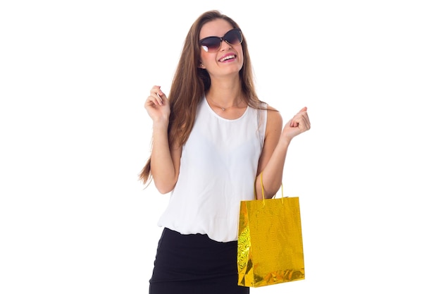 Young happy woman in white blouse and black skirt with dark sunglasses holding shopping bag