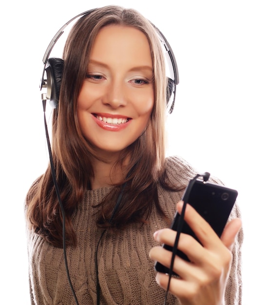 Giovane donna felice con le cuffie che ascolta musica su sfondo bianco