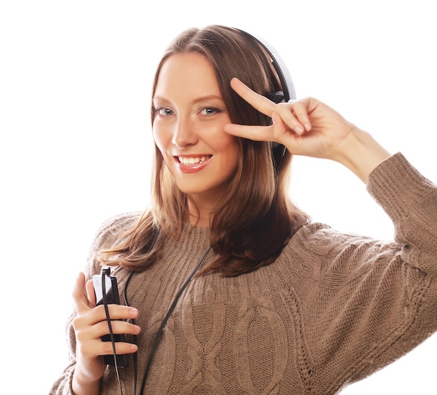 Young happy woman with headphones listening music over white background