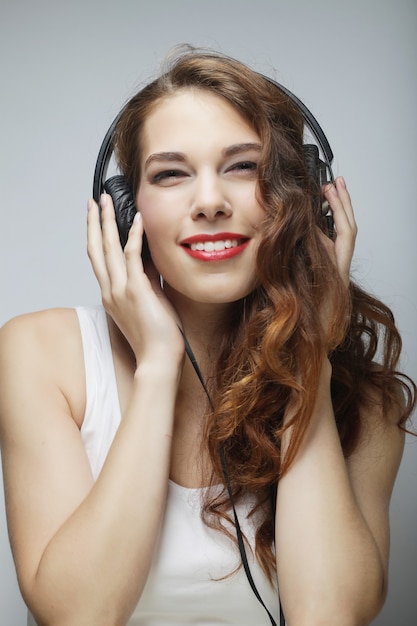 Young happy woman with headphones listening music