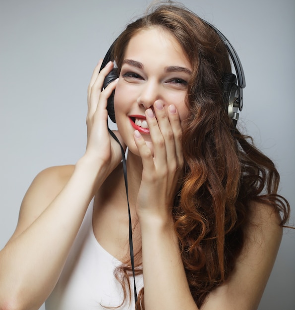 Young happy woman with headphones listening music