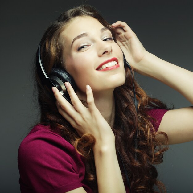 Young happy woman with headphones listening music