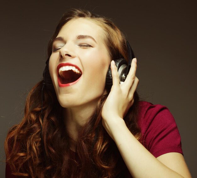 Photo young happy woman with headphones listening music