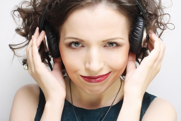 Young happy woman with headphones listening music