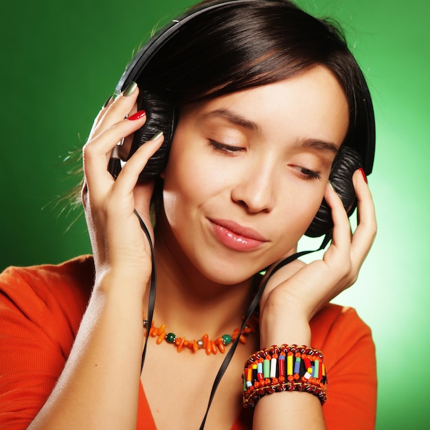 Young happy woman with headphones listening music