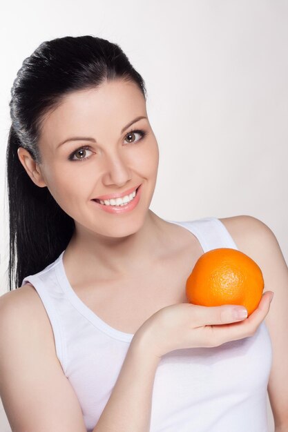 Young happy woman with oranges on isolated background