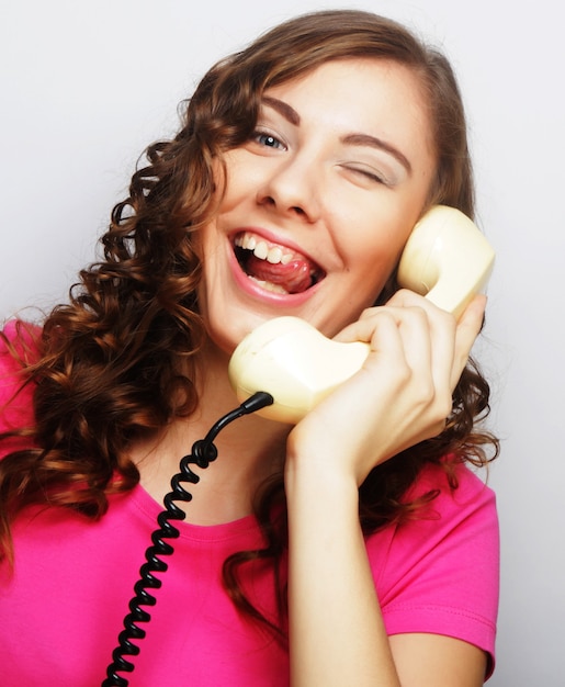 Young happy woman with vintage phone, studio shot