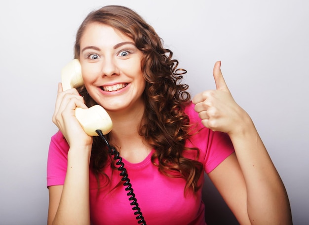 Foto giovane donna felice con telefono vintage