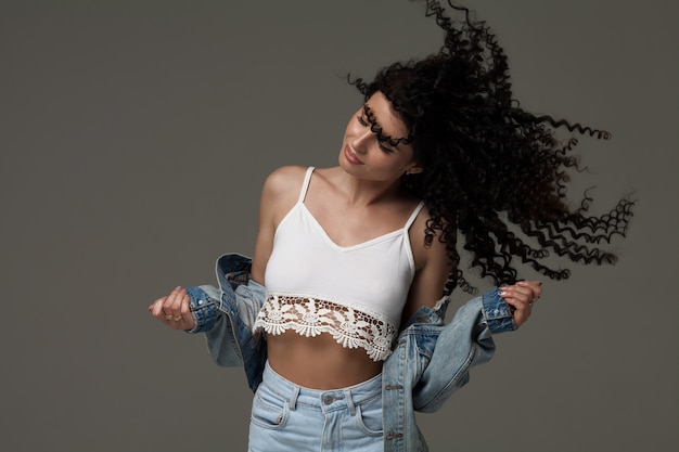 Young happy woman with wind in hair. Studio shot.