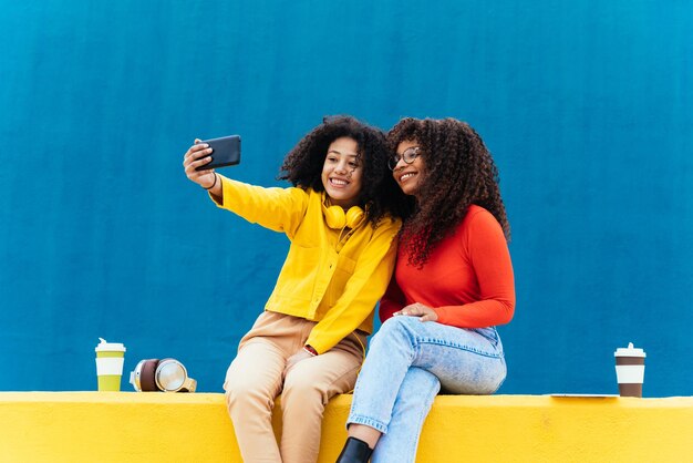 Young happy women taking selfies with the smartphone