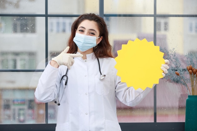 Photo young health care worker in mask holding idea bubble and pint finger at it
