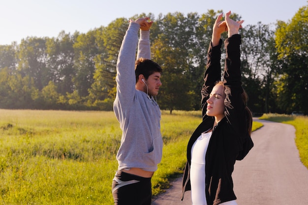 young health couple doing stretching exercise relaxing and warm up after jogging and running in park