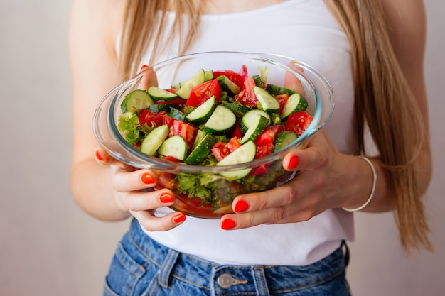 young healthy girl with a Cup of vegetable salad