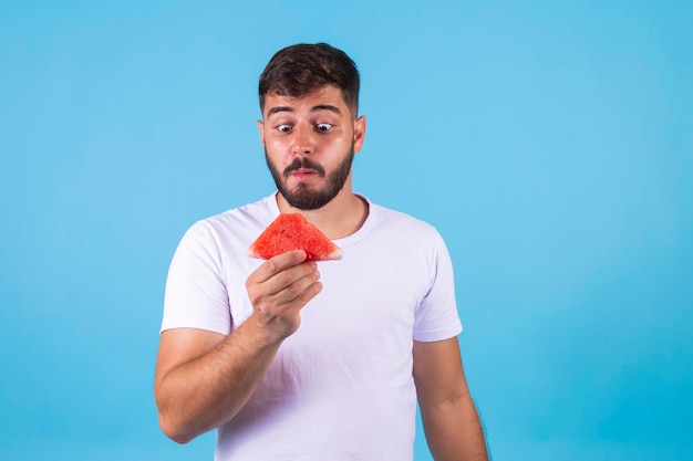 Young healthy handsome boy eating watermelon