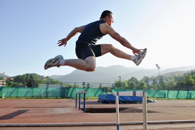 Young healthy man run on athletic race sport track and\
representing concept of sort and speed