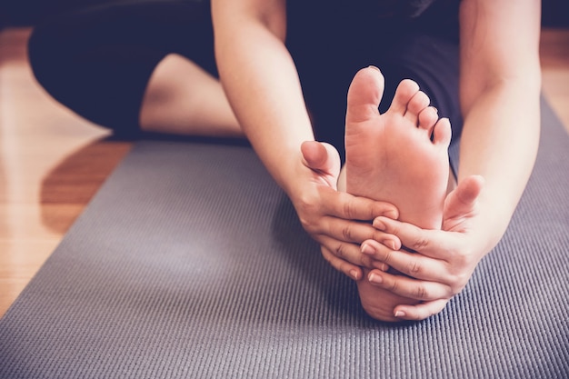 Young healthy woman practicing yoga lesson, stretching with instructor in home studio, wellness and fitness lifestyle 