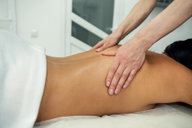 Foto donna giovane e sana nel salone termale terapia di massaggio tradizionale svedese e trattamenti di bellezza