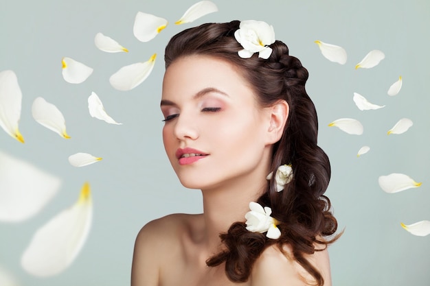 Young Healthy Woman with Perfect Hairstyle Makeup and White Rose Petals Pleasure and Purity Concept