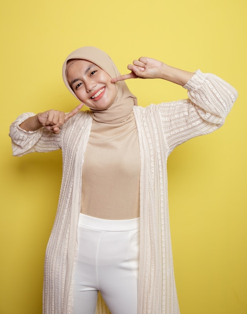 젊은 hijab 여자는 노란색 벽에 고립 된 매우 행복 미소