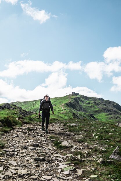 Young hiker man in mountains. summer trekking path. copy space.