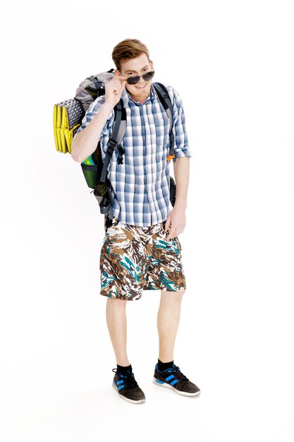 Young hiker in sunglasses with a backpack on a white background