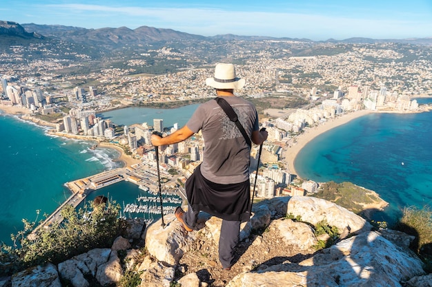 A young hiker at the top of the Penon de Ifach Natural Park in Calpe Valencia Valencian Community Spain Mediterranean sea View of the Cantal Roig and La Fossa beach