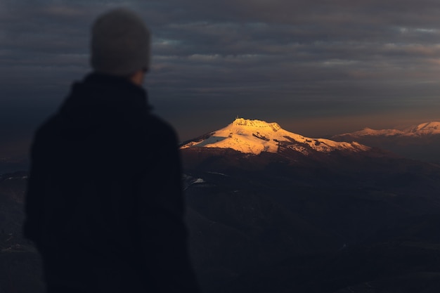 Young hiker at the top of a snowy mountain on winter.