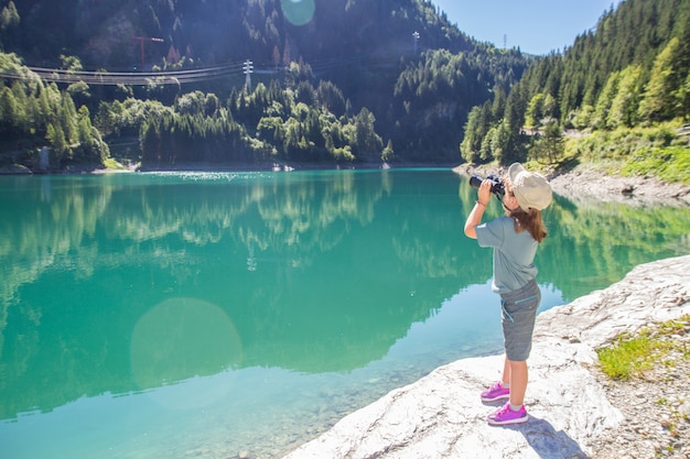 young hiker watches the panorama with the telescope