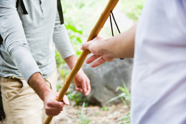 young hikers passing a stick