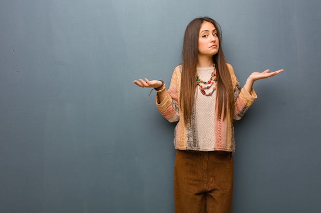 Young hippie woman doubting and shrugging shoulders