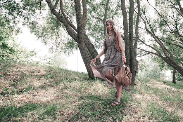 Young hippie woman enjoying a walk in spring forest