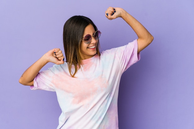 Young hippie woman isolated on purple space celebrating a special day, jumps and raise arms with energy.