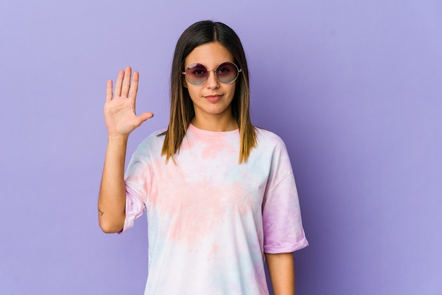 Young hippie woman isolated on purple wall smiling cheerful showing number five with fingers.