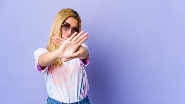 Giovane donna hippie con gli occhiali che fa un gesto di diniego