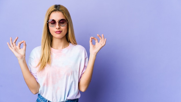 Young hippie woman with glasses relaxes, meditating