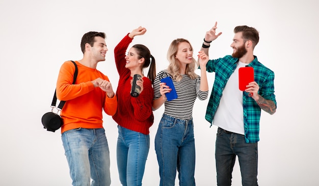 Foto giovane compagnia hipster di amici che si divertono insieme sorridendo ascoltando musica su altoparlanti wireless, ballando ridendo