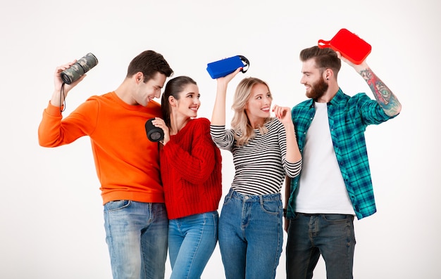 Young hipster company of friends having fun together smiling listening to music on wireless speakers, dancing laughing 