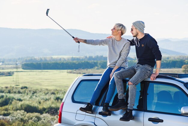 Young hipster couple in love making selfie using smart phone while