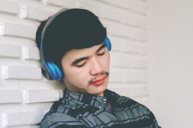 Young hipster gay man listening music headphones