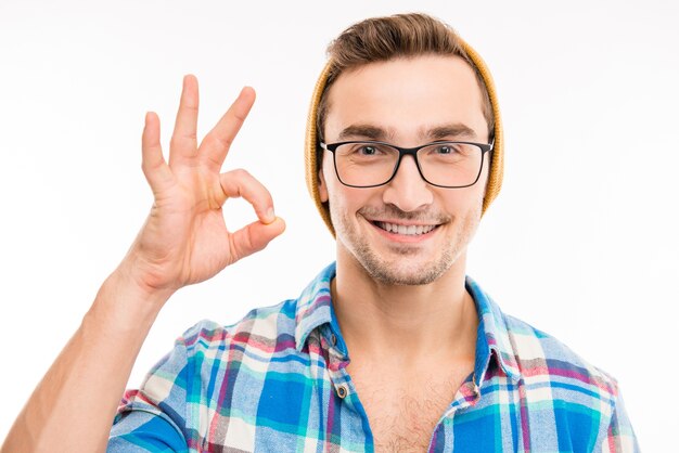 Photo young hipster in glasses in good mood shows