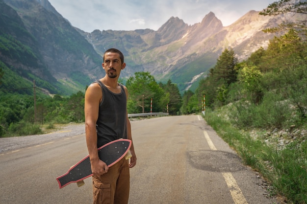 Young hipster holding a cool longboard in his hand