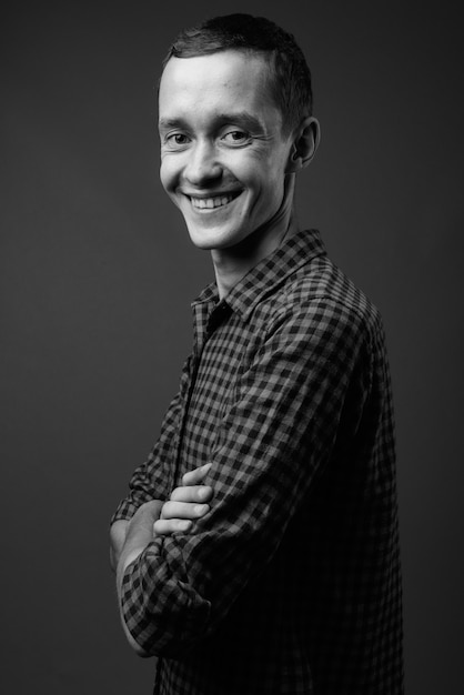  young hipster man against gray wall in black and white