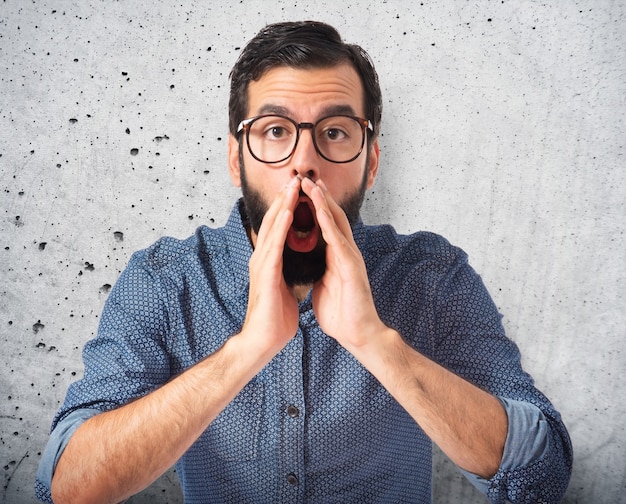 Young hipster man shouting over white background